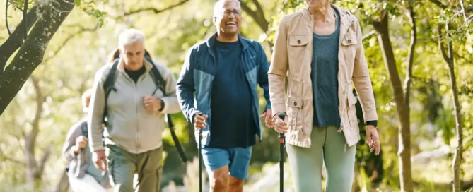 fitness over 65 - Older adult woman smiling while walking outdoors with walking poles