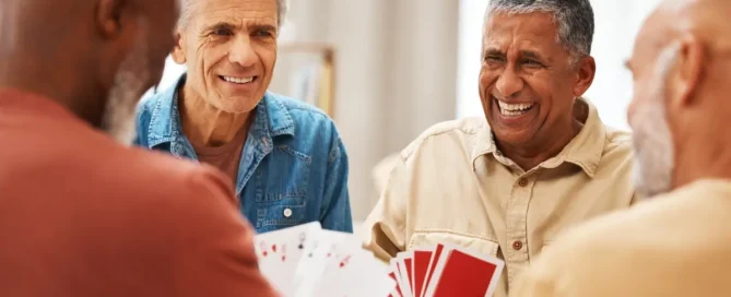 Seniors laughing and playing card games at an assisted living community in La Conner, Washington. Assisted Living vs. Memory Care